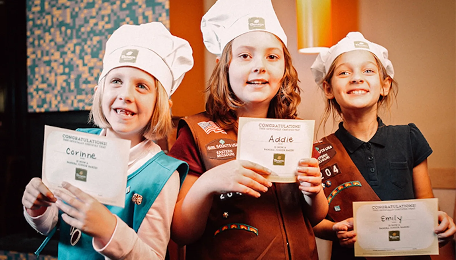 A group of girlscouts holding their Panera certificates