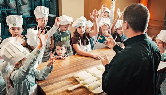 A group of boys and girls learning about Panera Bread Company